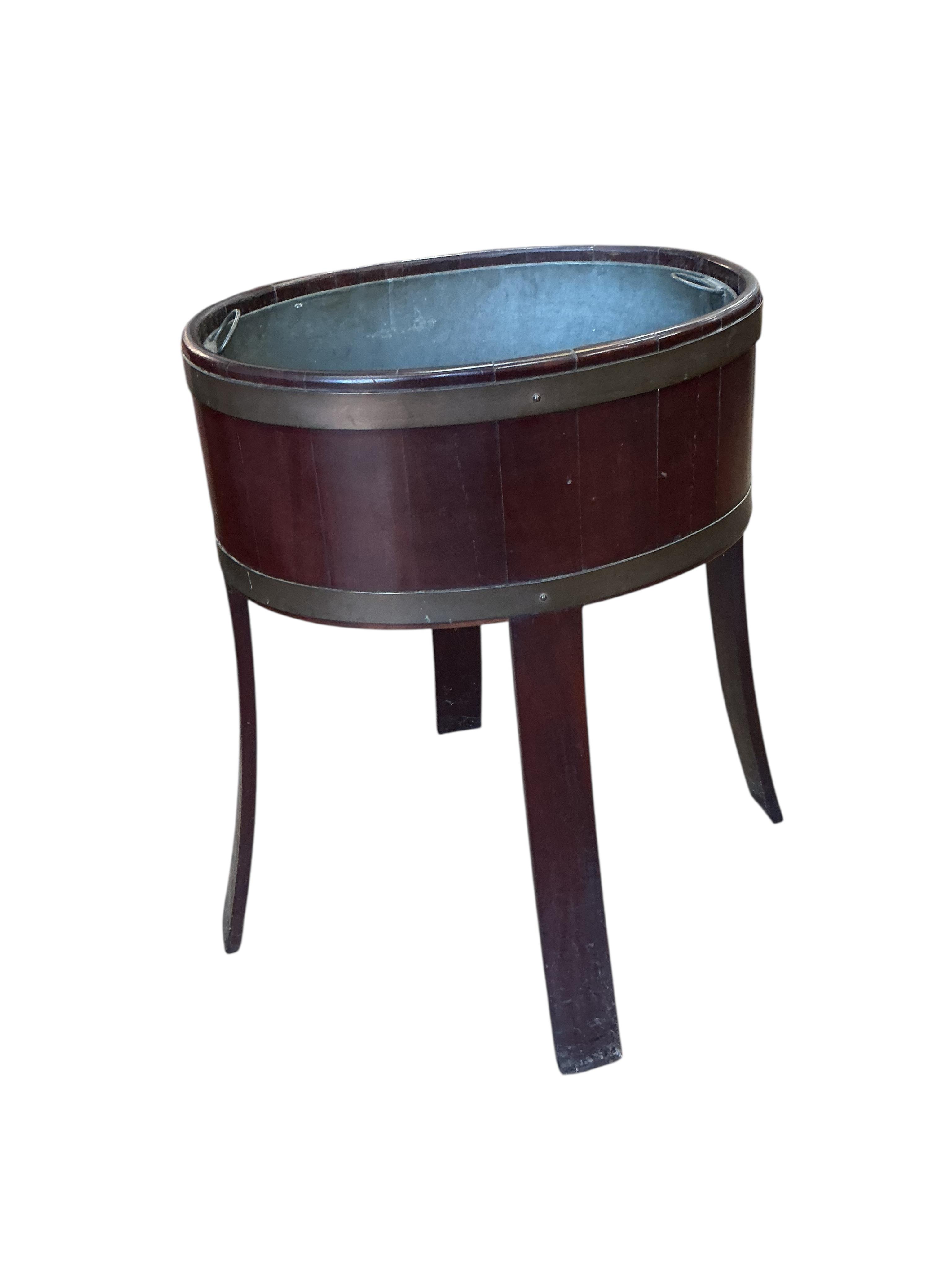 A brass bound oval mahogany jardiniere with liner, width 48cm, depth 34cm, height 62cm